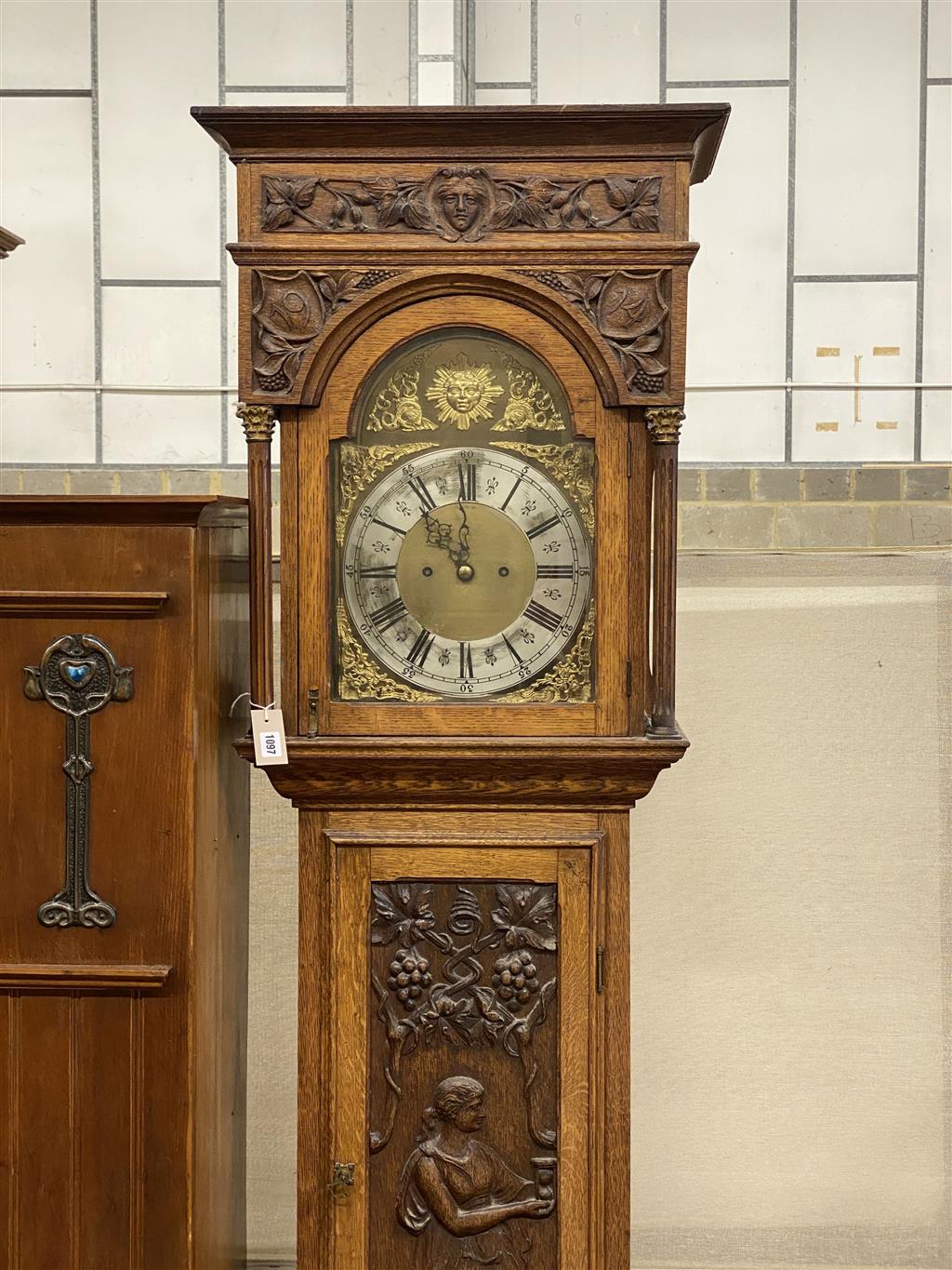 A 1914 carved oak eight day longcase clock, height 230cm